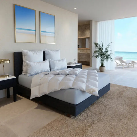 Helles Schlafzimmer mit luxuriös bezogenem Bett, hochwertigen Kissen und Bettdecken aus der Hanse Excellence Kollektion.