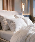 Mehrere HANSE Premium Kissen am Kopfteil eines Hotelbetts, im Hintergrund ein Fenster mit Meerblick