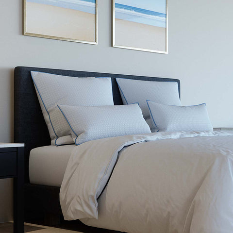 Modernes Schlafzimmer mit mehreren weißen Kühlkissenbezügen auf einem stilvoll bezogenen Bett, ideal für kühl schlafen und erholsame Nächte