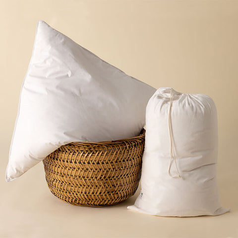 Premium 1-Kammer-Kissen zusammen mit weiteren Kissen in einem Korb arrangiert, hochwertig verarbeitet und in klassischem Weiß gehalten.