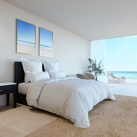 Modern eingerichtetes Schlafzimmer mit weißem Select Bettdeckenbezug auf stilvollem Bett und entspannendem Meerblick